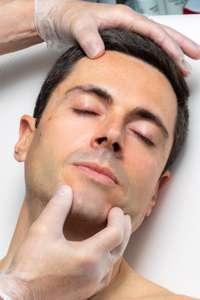 Close up portrait of middle aged man having skin examination in clinic