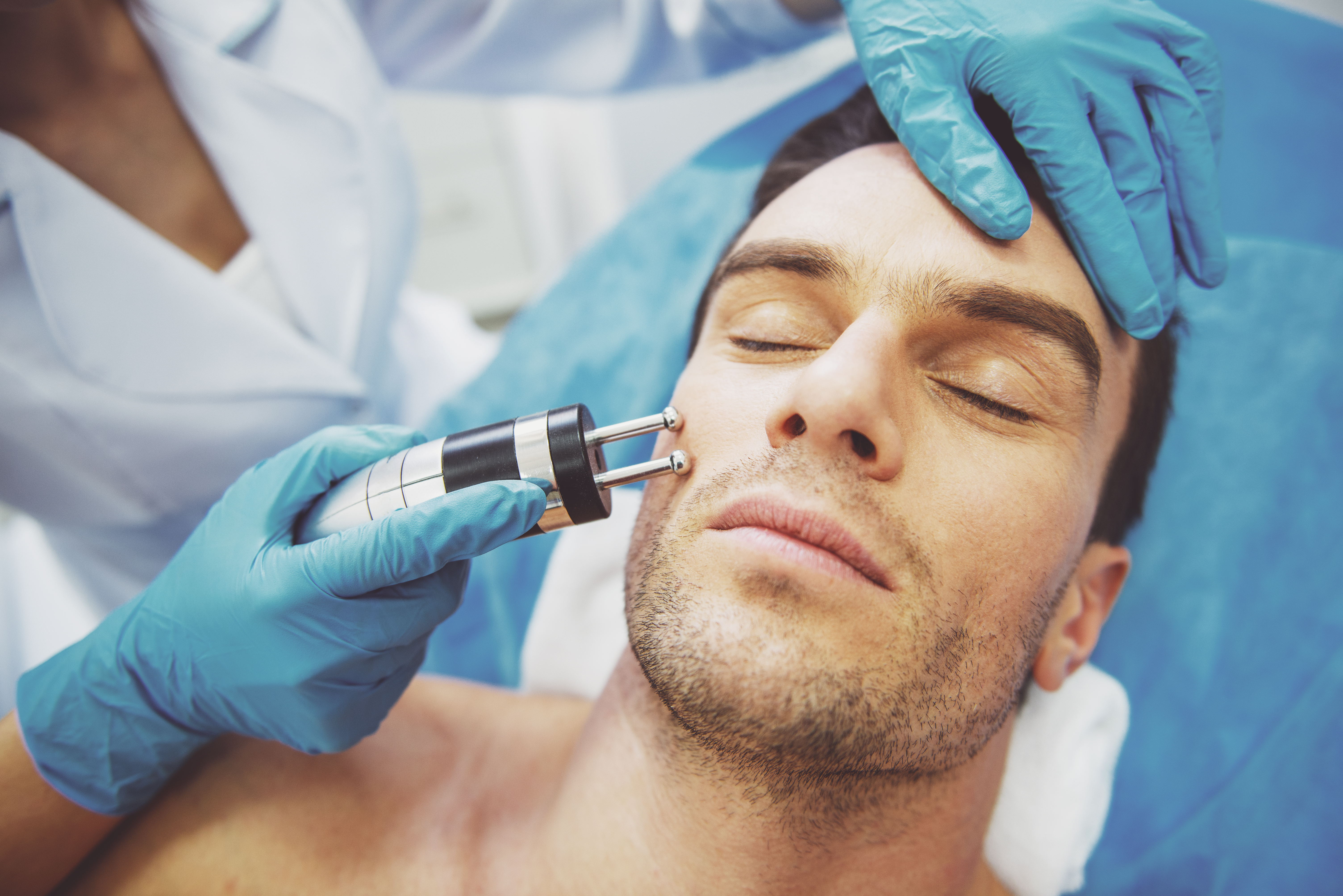 Man receiving a professional facial treatment at a skincare clinic.