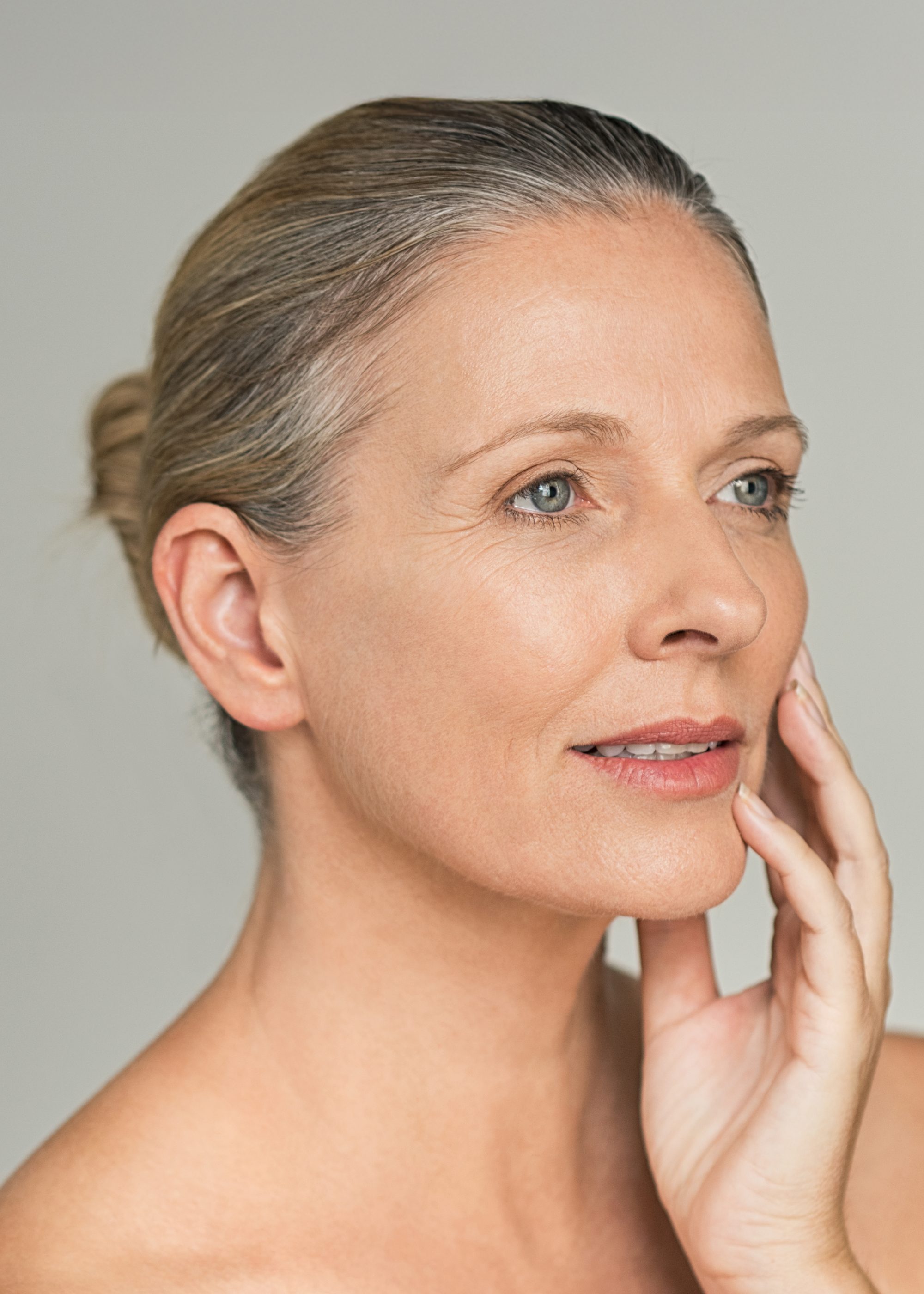 Beautiful older woman touching her face